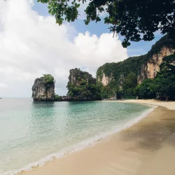 Tranquil beach scene with limestone cliffs in Thailand, perfect for tropical escapes.
